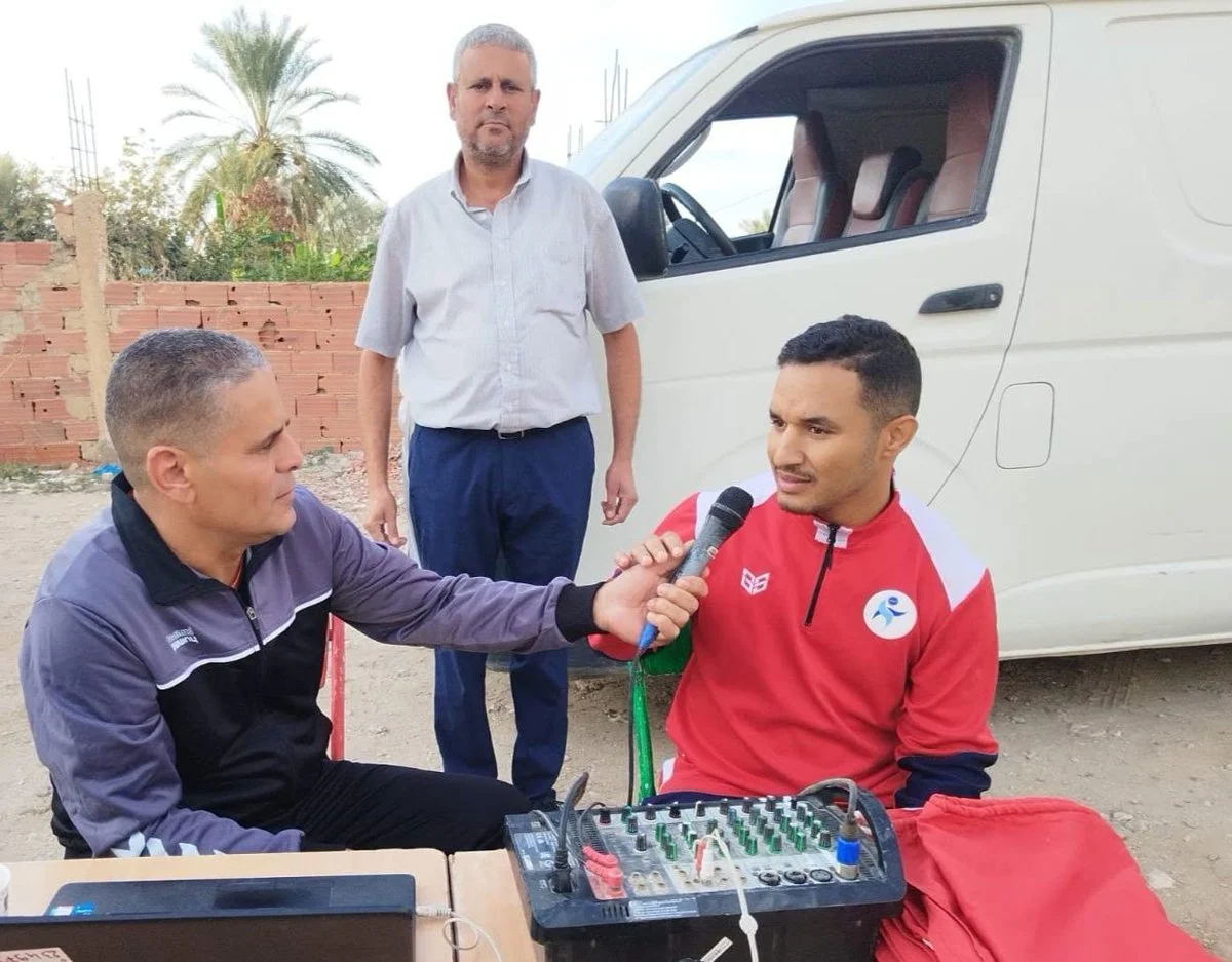 أحد المنظمين يتحدث في الميكروفون خلال تنشيط التظاهرة الرياضية