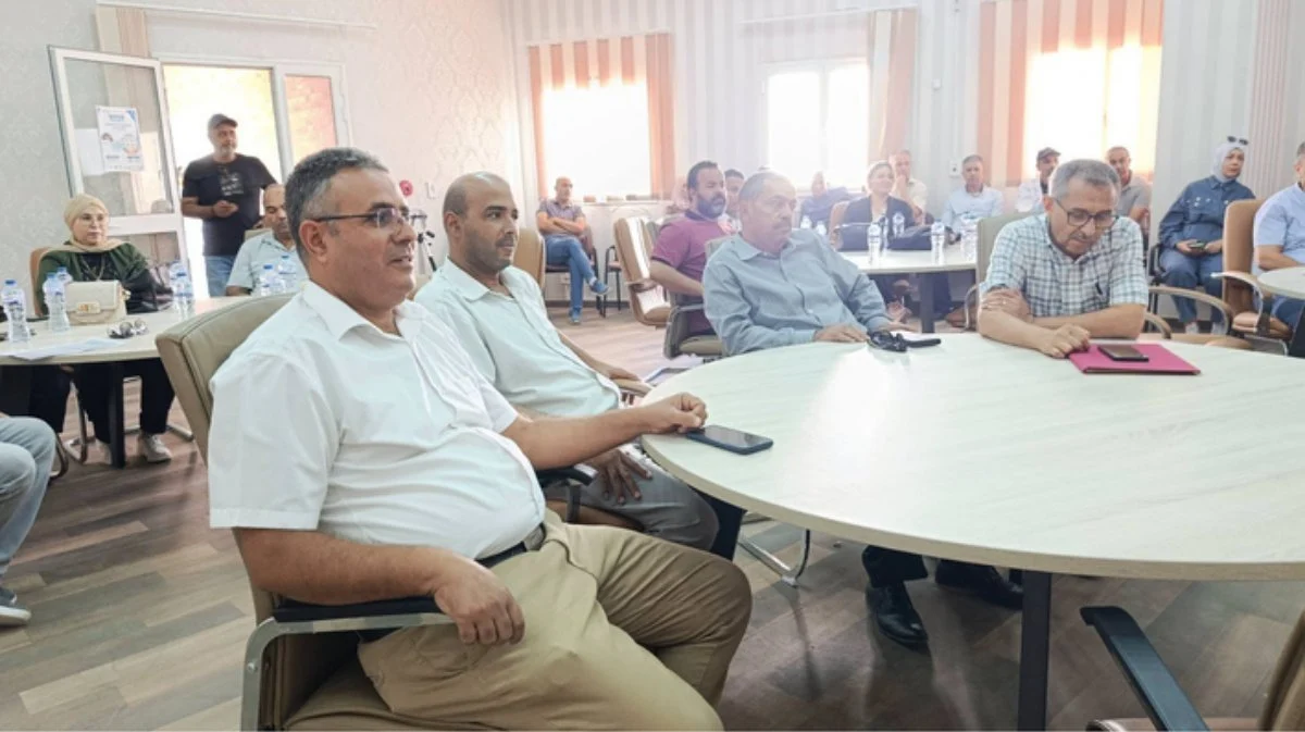 أساتذة جالسون حول طاولات مستديرة في قاعة الحفل بكلية العلوم بقفصة