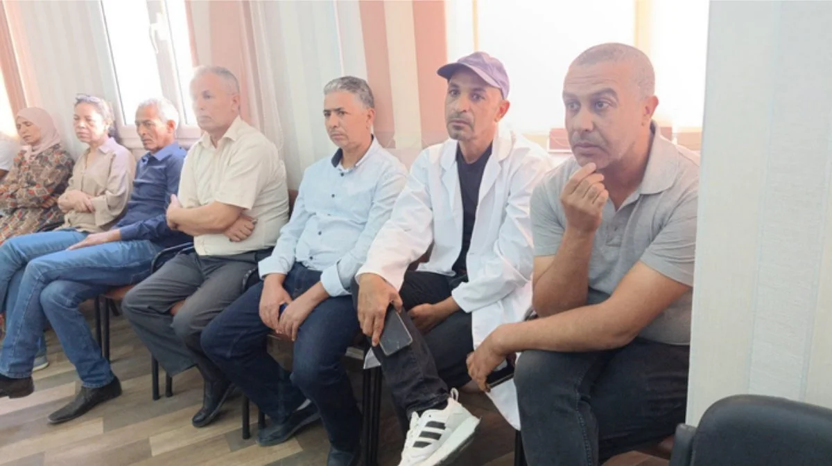 صف من الحاضرين بينهم رجل بميدعة بيضاء يتابعون الحفل
