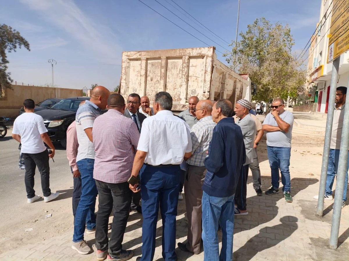 مجموعة من الرجال يتحدثون عند شاحنة قلابة في أحد شوارع حي الإخوة بسيدي أحمد زروق بقفصة