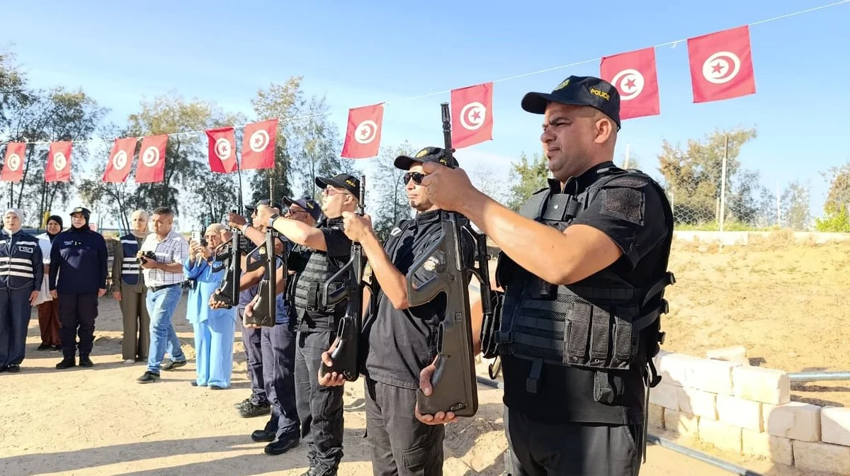 أعوان أمن يحملون أسلحتهم عموديا في وضعية التحية خلال رفع العلم بجمعية التفاؤل بقفصة