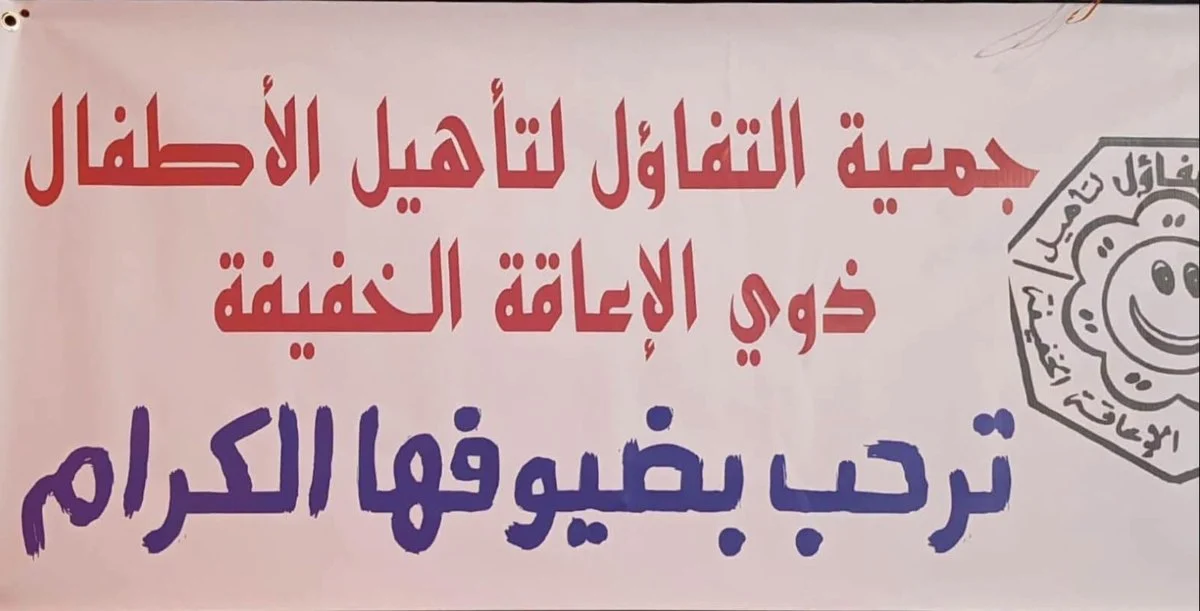 لافتة جمعية التفاؤل لتأهيل الأطفال ذوي الإعاقة الخفيفة بقفصة مكتوب عليها «ترحب بضيوفها الكرام»