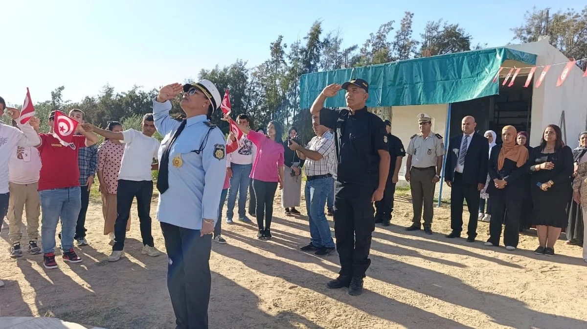 عونا أمن وأطفال وشباب جمعية التفاؤل يؤدون التحية للعلم في ساحة المقر بالمركز الفلاحي بقفصة