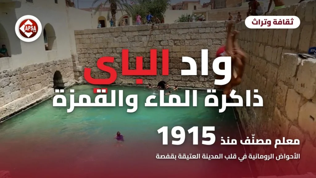 شاب يقفز من أعلى سور حجري في الأحواض الرومانية بقفصة وسابحون في الماء الأخضر، مع عنوان «واد الباي: ذاكرة الماء والقمزة» وشعار راديو كابصا اف ام