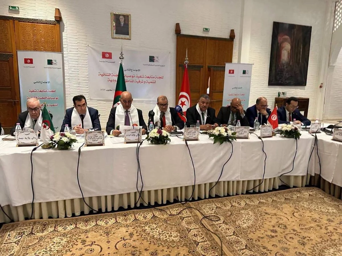 قاعة اجتماع اللجنة الثنائية بالوادي وعلى الطاولة علما تونس والجزائر ولافتات الاجتماع الثاني لمتابعة التوصيات
