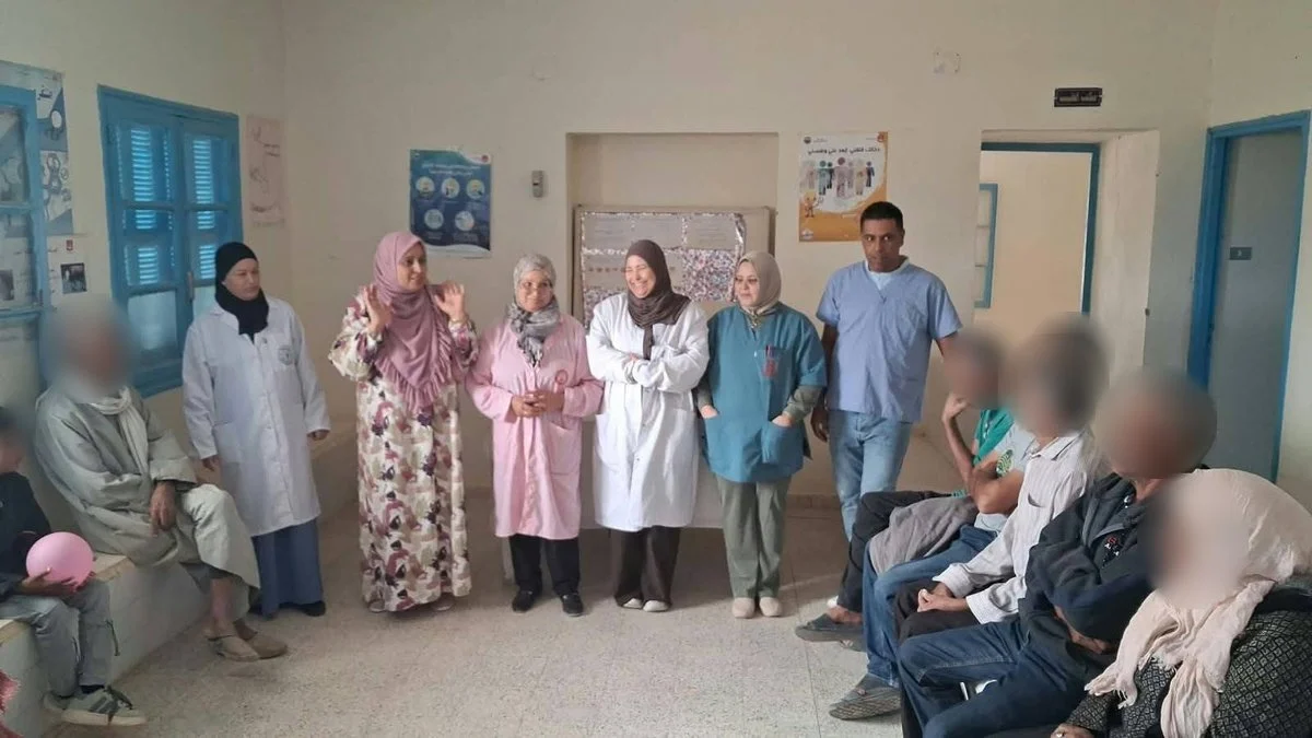 إطارات صحية بمآزر بيضاء ووردية وزرقاء تقف وسط قاعة المستوصف خلال حصة تحسيسية مع كبار السن