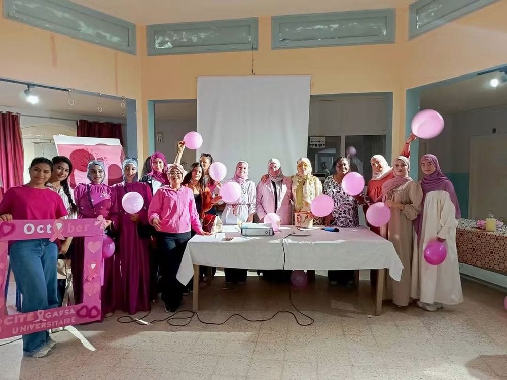 طالبات وإطارات صحية بملابس وردية يرفعن بالونات وإطار «October» في قاعة بأحد المبيتات الجامعية بقفصة