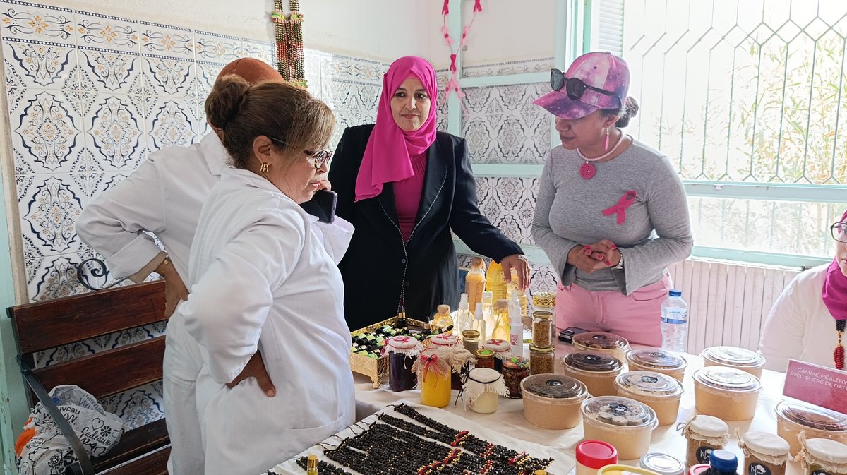 زائرات وممرضة أمام طاولة منتوجات الحرفيات في فضاء العيادات الخارجية بقفصة