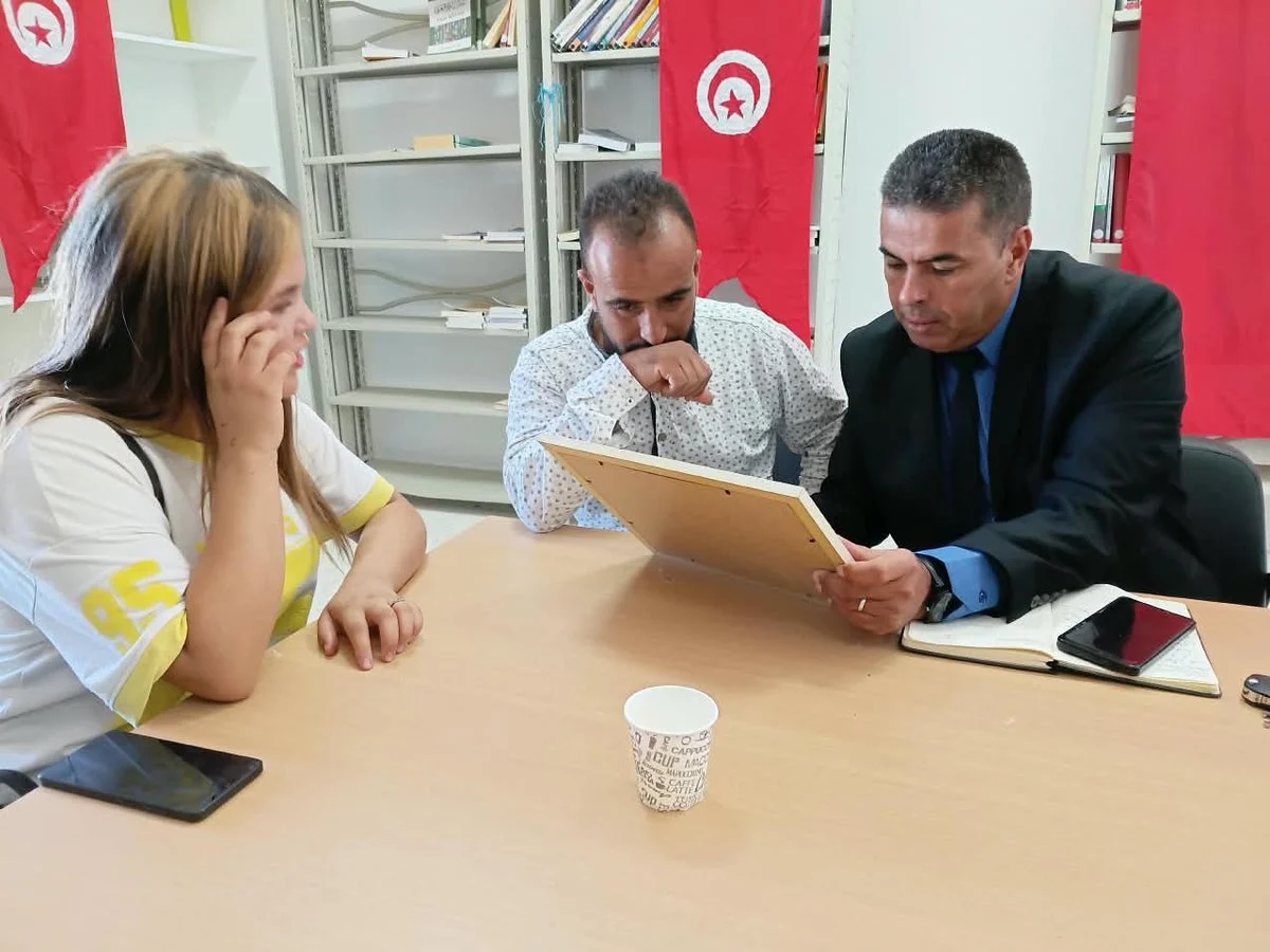 ممثل البنك التونسي للتضامن يطّلع على شهادة تكوين مؤطّرة رفقة شابة وشاب خلال اليوم التحسيسي بالمكتبة العمومية بسيدي بوبكر