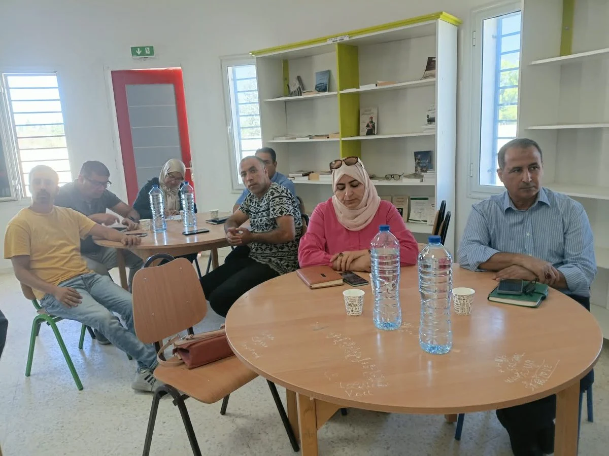 حاضرون حول طاولة مستديرة قرب رفوف الكتب في المكتبة العمومية بسيدي بوبكر خلال اليوم التحسيسي