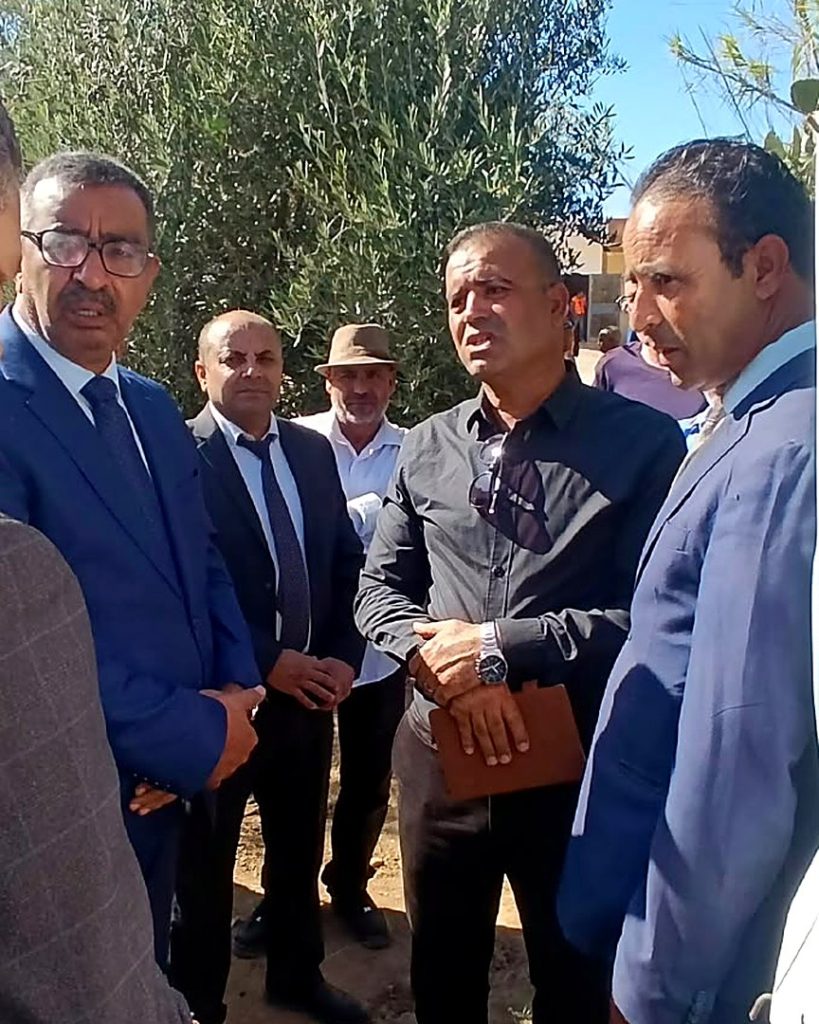 مسؤولون جهويون ومحليون يستمعون إلى أحد الفلاحين بجانب شجرة زيتون في ضيعة بسيدي بوبكر