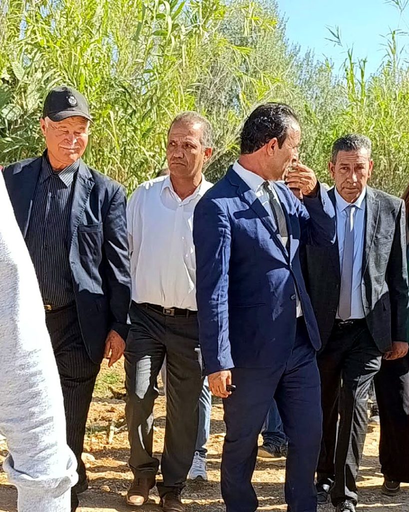 أعضاء الوفد يسيرون في مسلك ترابي بين القصب والأشجار بمعتمدية سيدي بوبكر