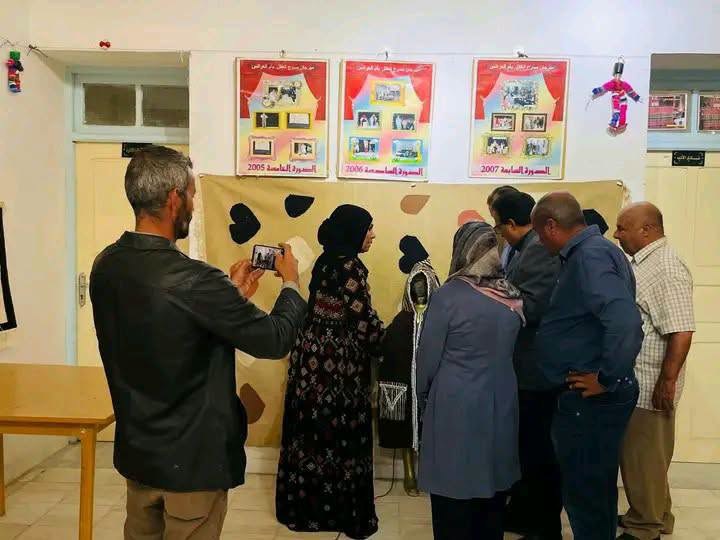 زوار يتأملون ويصوّرون معرضا لمعلقات الدورات السابقة للمهرجان الدولي لمسرح الطفل بدار الثقافة بأم العرائس