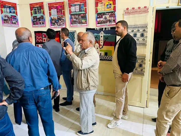 زائر يصوّر منسوجات تقليدية ومعلقات معروضة بدار الثقافة بأم العرائس خلال افتتاح المهرجان
