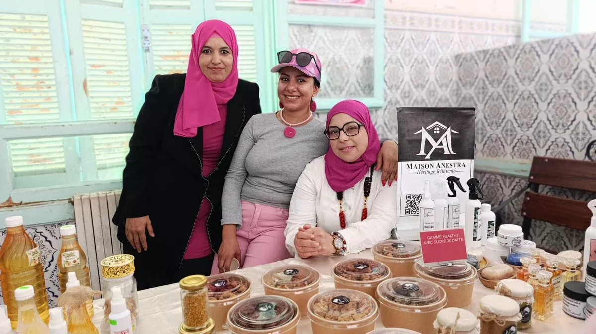 ثلاث مشاركات بأوشحة وردية أمام منتوجات طبيعية معروضة في اليوم التحسيسي بقفصة